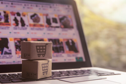 Online shopping - Paper cartons or parcel with a shopping cart logo and credit card on a laptop keyboard. Shopping service on The online web and offers home delivery.